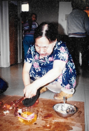 This Puvirnituq elder, who hosted my first country foods meal in November 1991, deftly slices caribou with an ulu. (PHOTO BY JANE GEORGE)