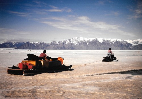 A heavily-laden komatik pulled by a snowmobile heads out of Pond Inlet on the ice in the mid-1990s. (PHOTO BY JANE GEORGE)